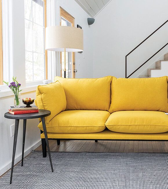 A yellow sofa in a light and cool appartment