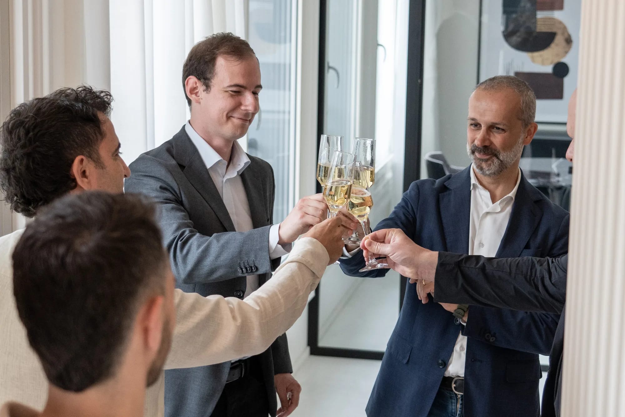 A group of guests raise their glasses of sparkling wine in a toast