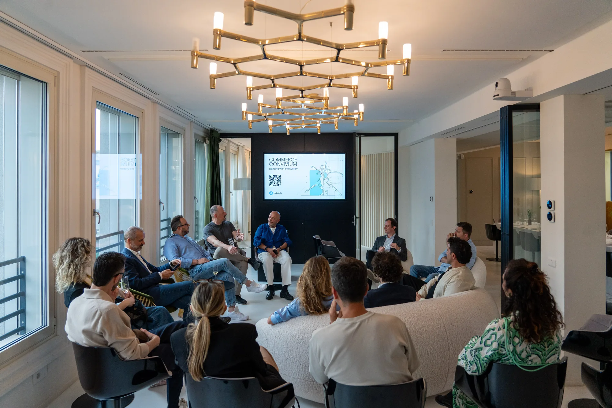 Guests seated in a circle for the roundtable, with the event title on a screen behind