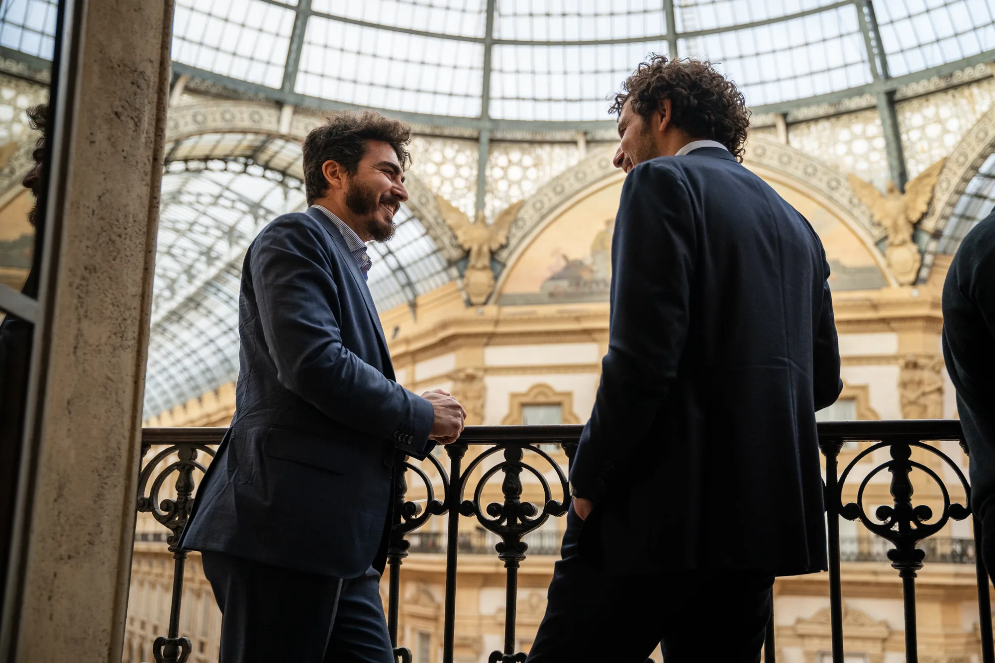 Two guests talking on a balcony overlooking the glass roof of Galleria Vittorio Emanuele II