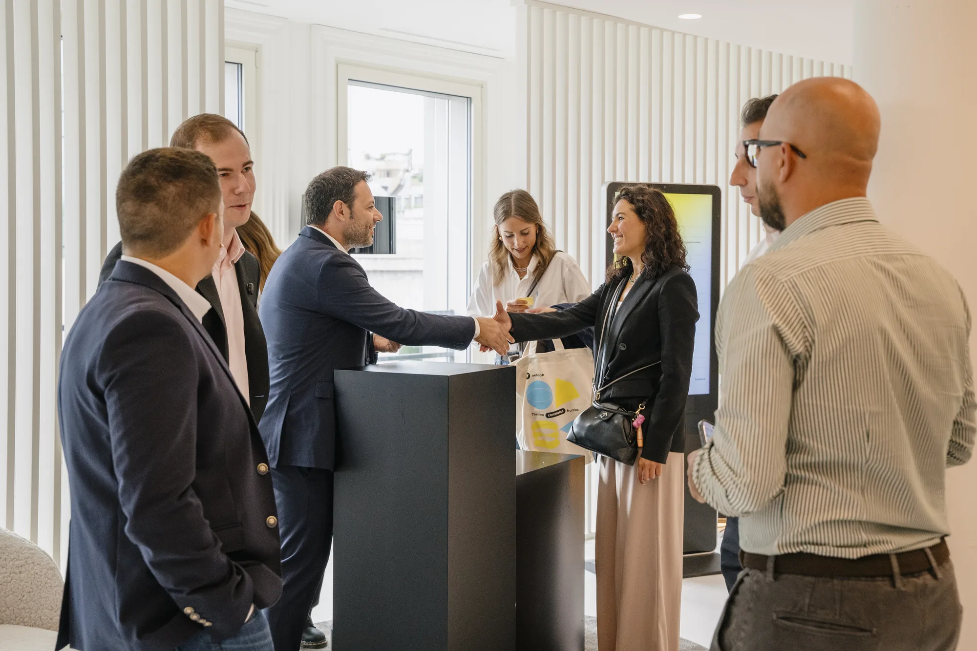 Guests shake hands and greet each other at the check-in desk