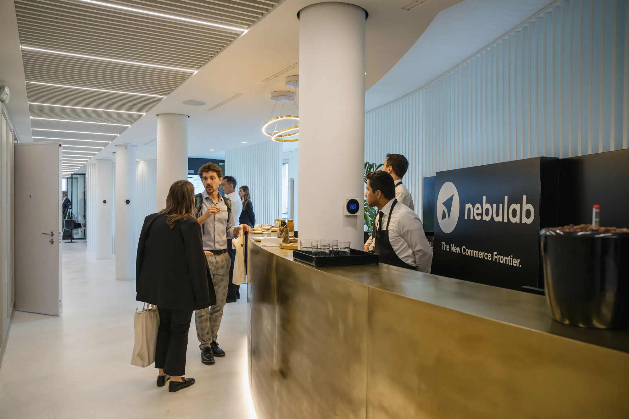 Brass reception counter with Nebulab signage in a bright hallway lined with columns