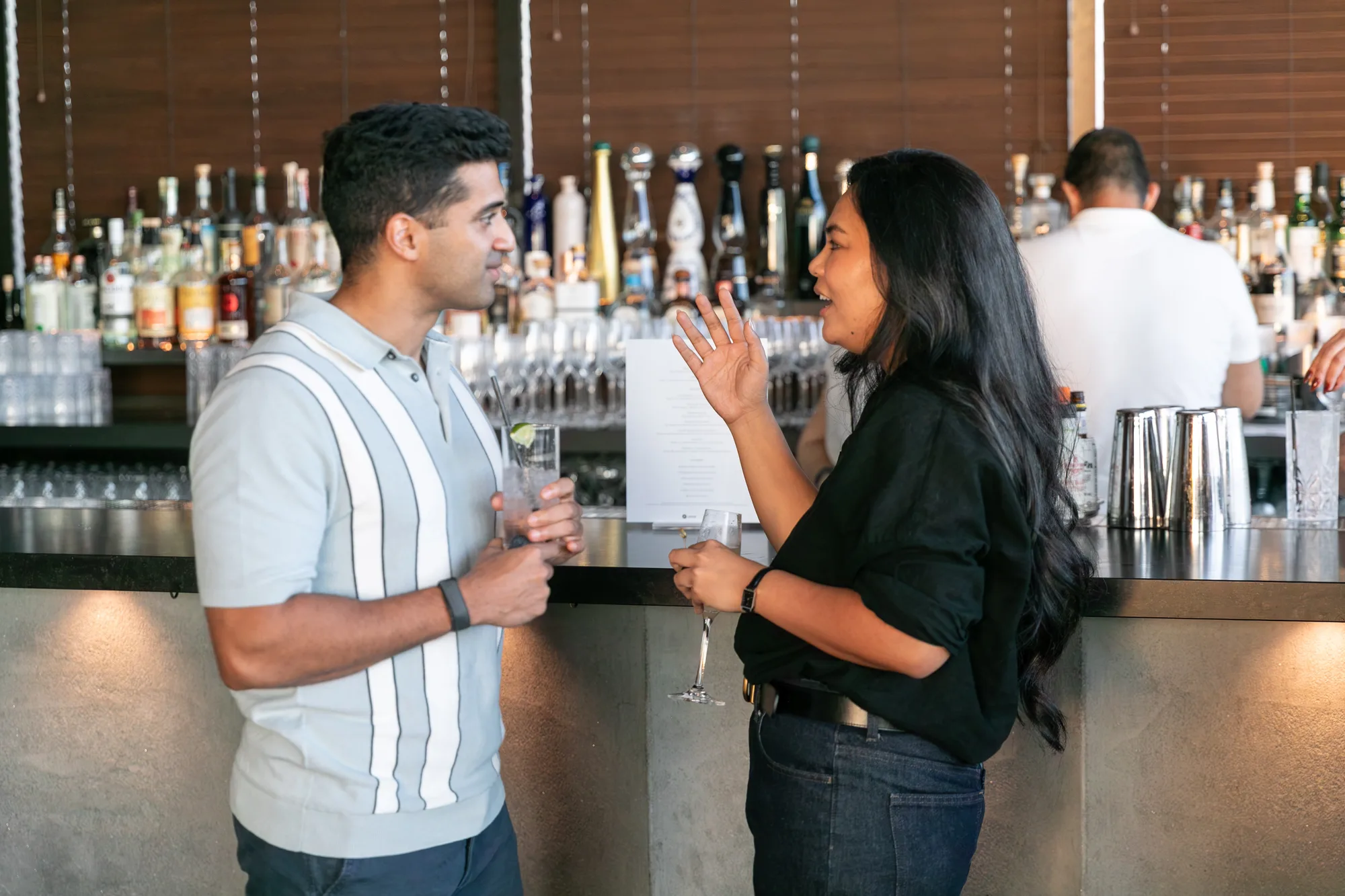 Two attendees talking over drinks at the rooftop bar