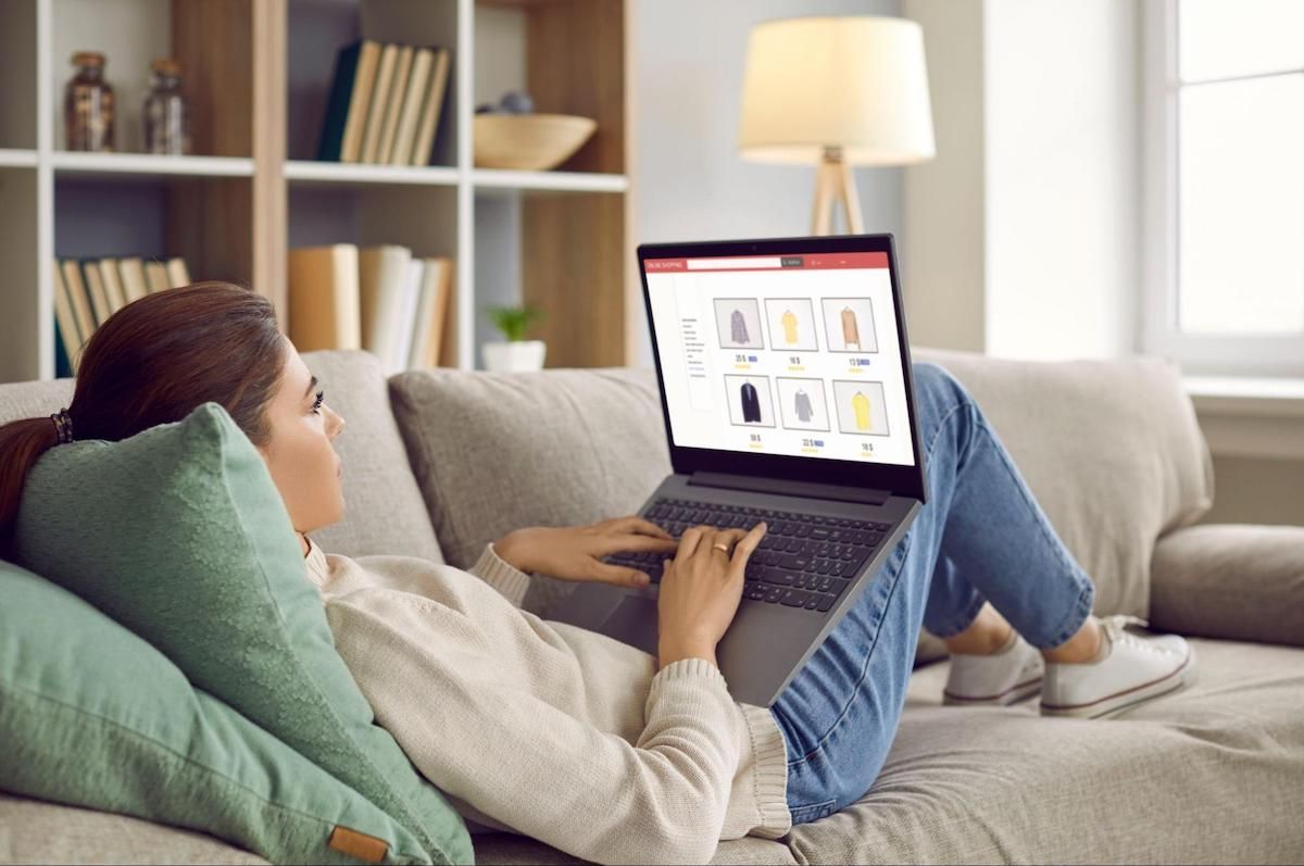 Woman lying on a couch and using a laptop