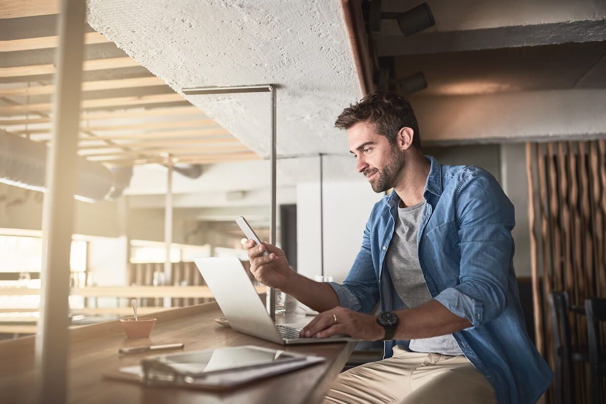 Entrepreneur using his phone and laptop