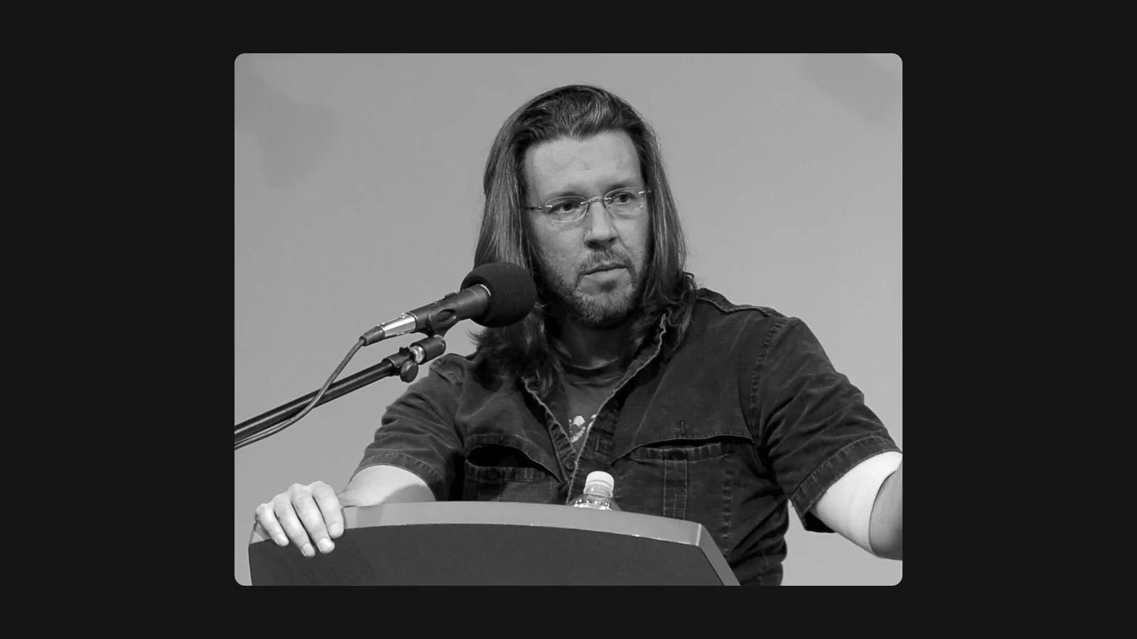 David Foster Wallace speaking at a podium.